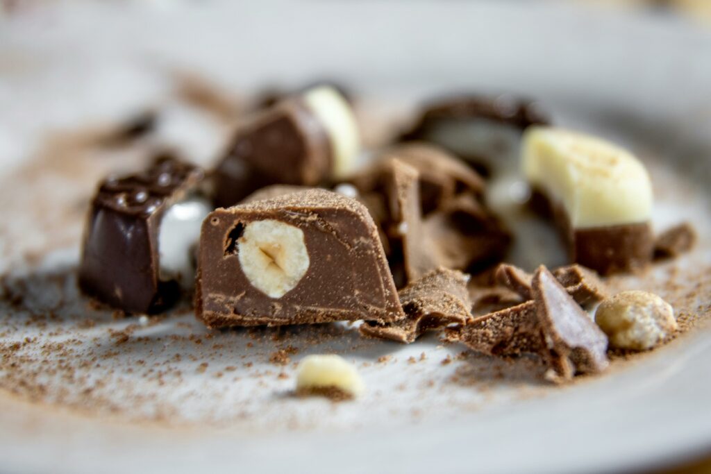 Delicious close-up of assorted chocolate pralines and nuts on a plate.