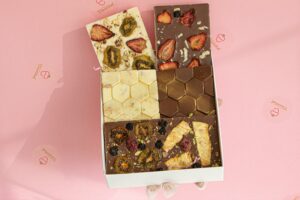 Delicious assortment of gourmet chocolates topped with dried fruits in a box.